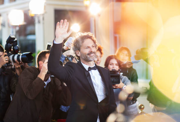 celebridades saludando a los paparazzi en el evento - handsome man flash fotografías e imágenes de stock