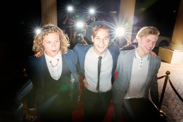 Smiling celebrities walking in a row at red carpet event  boy band stock pictures, royalty-free photos & images