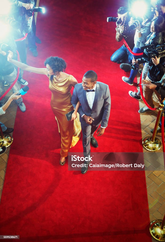 Celebrity couple arriving at event waving and walking the red carpet  Red Carpet Event Stock Photo
