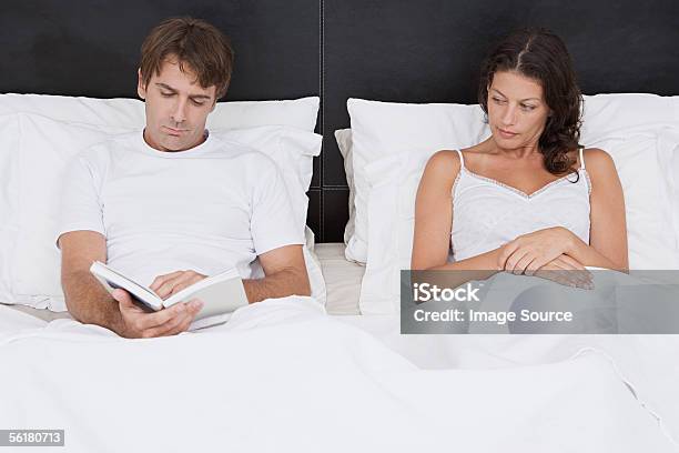 Couple Sitting Up In Bed Stock Photo - Download Image Now - 30-39 Years, Adults Only, Bed - Furniture