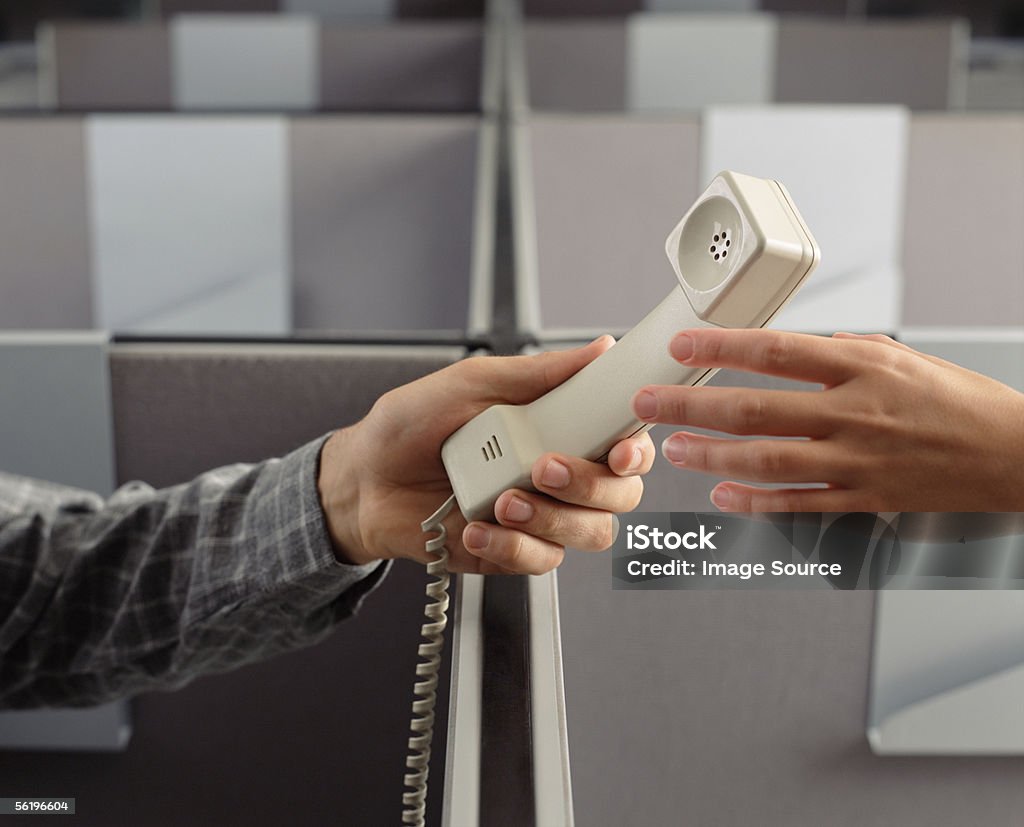 Man handing telephone receiver to woman  Call Center Stock Photo