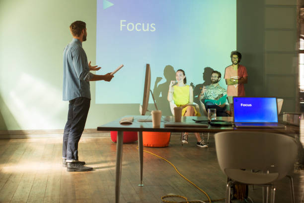 フォーカスでオーディオビジュアルプレゼンテーションを準備しているビジネスの人々 - text ready ストックフォトと画像