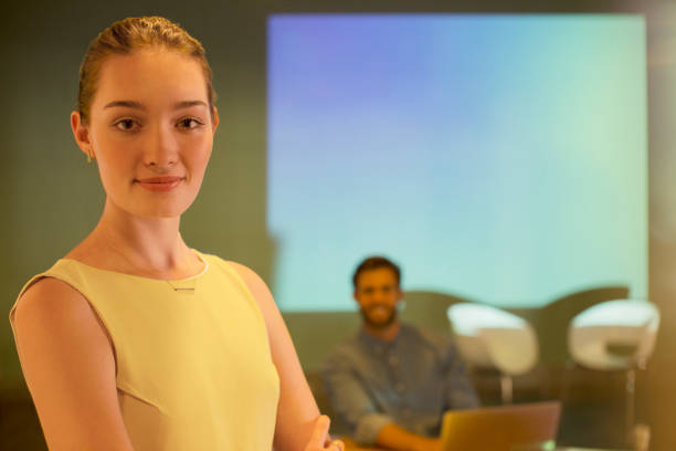 istock Portrait confident businesswoman in audio visual presentation on Focus 562872525