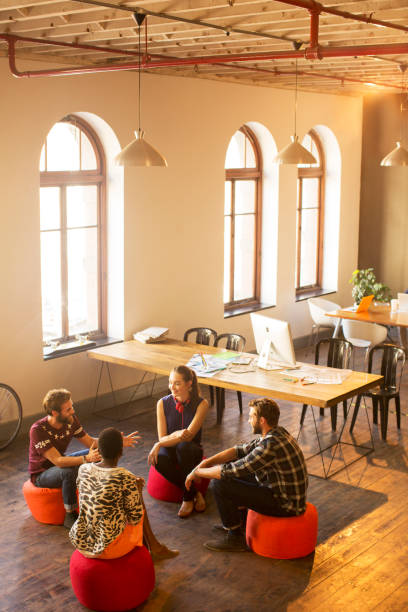 istock Creative business people talking in circle in office 562872547