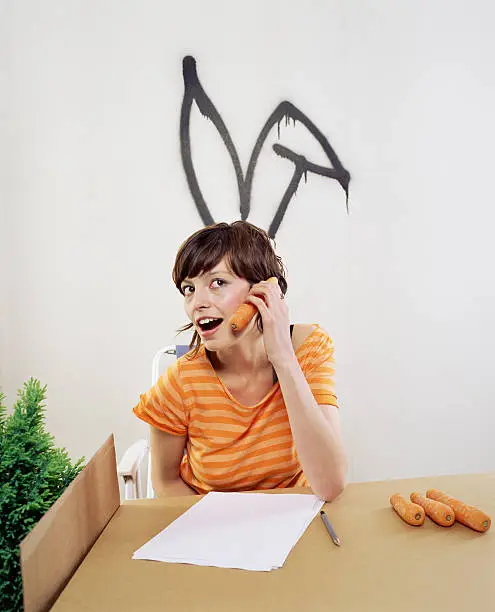 Photo of Woman using a carrot as a telephone