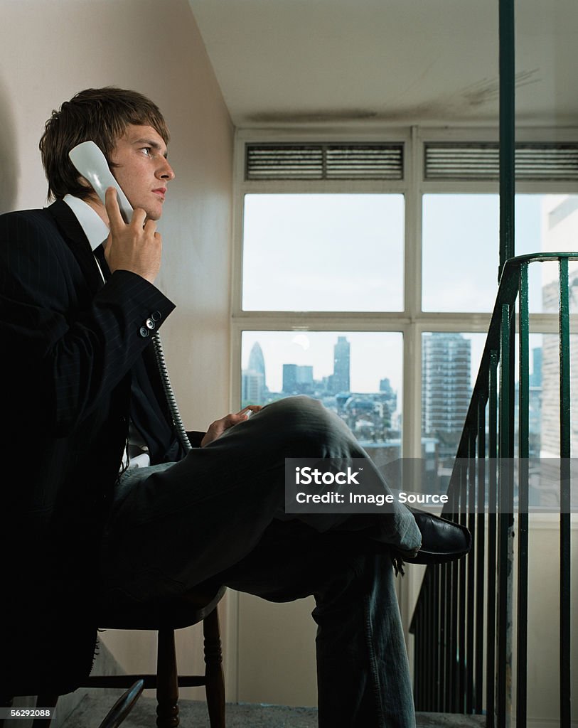 Businessman using a telephone in corridor  Telephone Receiver Stock Photo