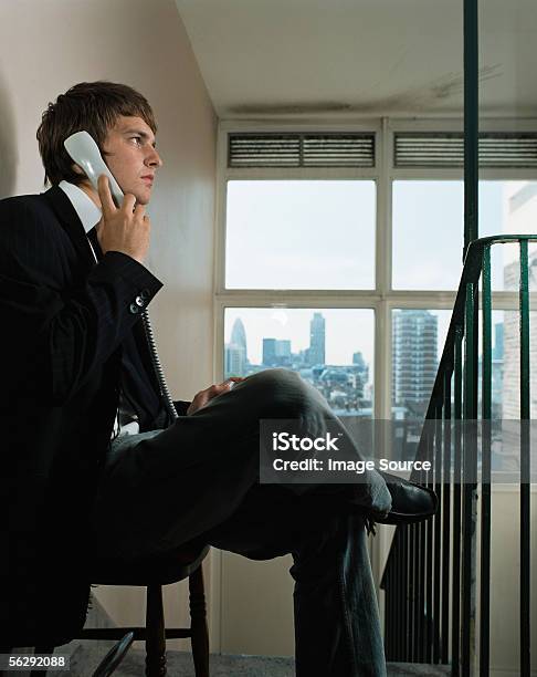 Businessman Using A Telephone In Corridor Stock Photo - Download Image Now - Telephone Receiver, Profile View, Talking