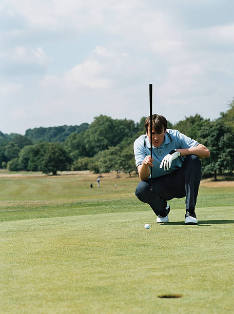 golfer preparing to take a shot - golf golf course putting green hole stock-fotos und bilder