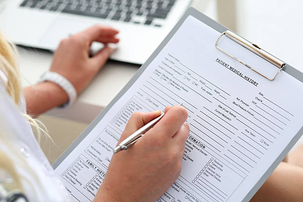 Female doctor hold clipboard pad Female doctor hold clipboard pad and fill medical history list with silver pen. Physical, disease prevention, 911, prescribe remedy, ward round, therapeutist assistance, healthy lifestyle concept anamnesis stock pictures, royalty-free photos & images