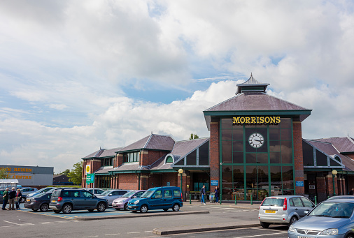 Telford, England - June 15, 2016:  An editorial photo of the Morrisons supermarket in Wellington, United kingdom. Morrison Supermarkets is the fourth largest chain of supermarkets in the United Kingdom. People can be seen parking their cars and entering the store. 