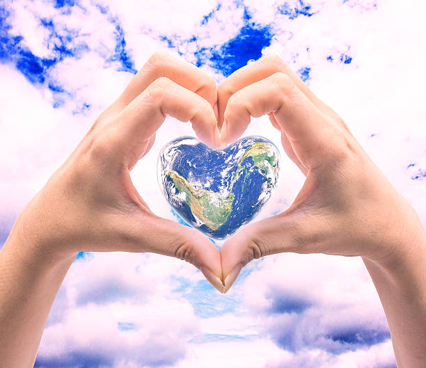 istock World in heart shape with over women human hands 564564766