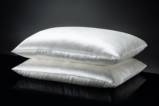 Studio product shot of a stack of pillows on black, reflective background. Concept image for safety.