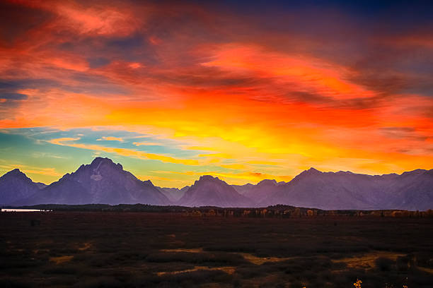 istock burning sky and Grand Teton mountains at sunset. 564567486