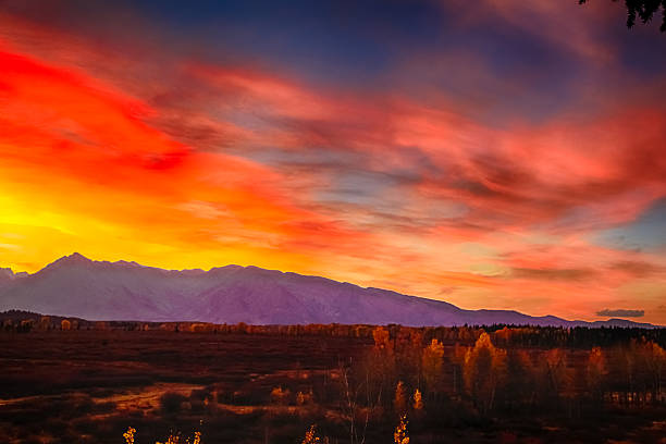 istock burning sky and Grand Teton mountains at sunset. 564567542