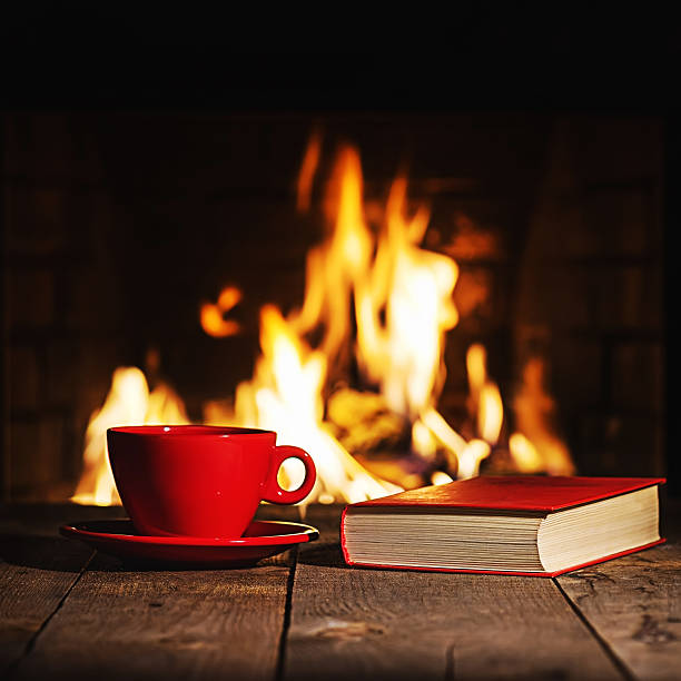istock Red cup of coffee or tea and old book 564567802