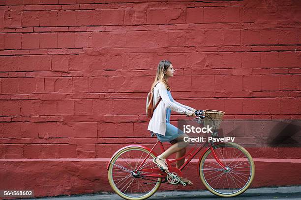 Young Woman Cycling In The Street Stock Photo - Download Image Now - Cycling, Bicycle, Red