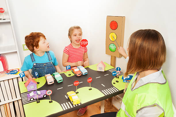 des enfants d’âge préscolaire heureux à la leçon de sécurité routière - red vest photos et images de collection