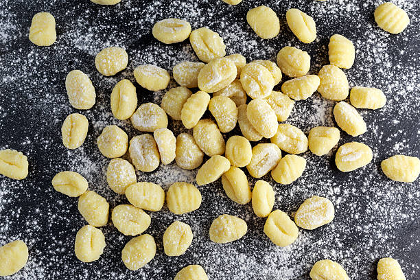 istock Uncooked homemade gnocchi on stone cutting floured board. 564572132