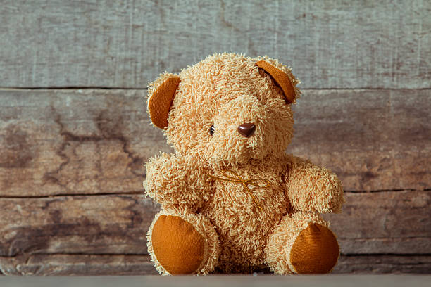 istock Cute teddy bears sitting on old wood background 564574352