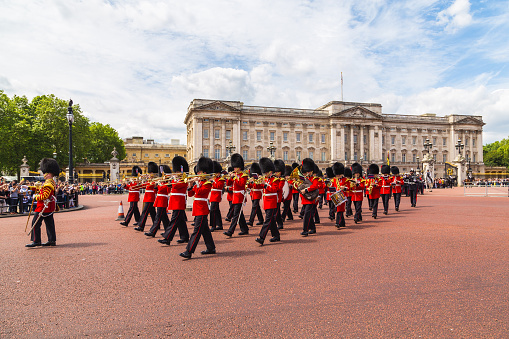 London, UK - June 28, 2016: Musical support from the Regimental Band during the Changing of the Guard ceremony at Buckingham Palace in the summer.  The soldiers can be seen wearing scarlet tunics and bearskin caps