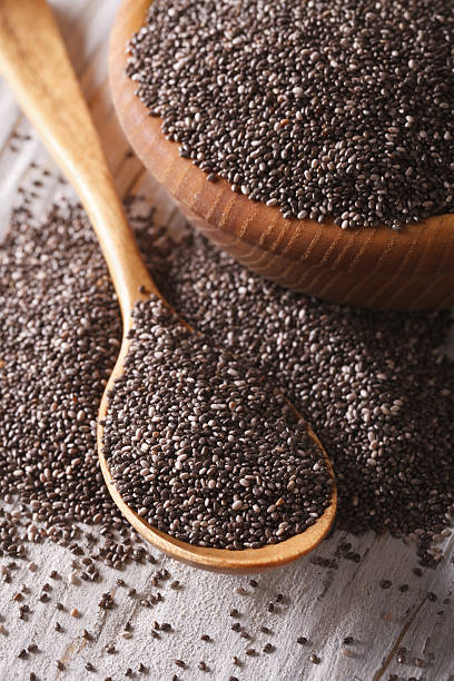 istock Healthy Chia seeds in a wooden spoon macro. vertical 564578308