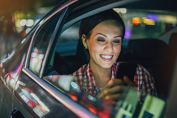 istock Young woman texting in a car at night 564578462