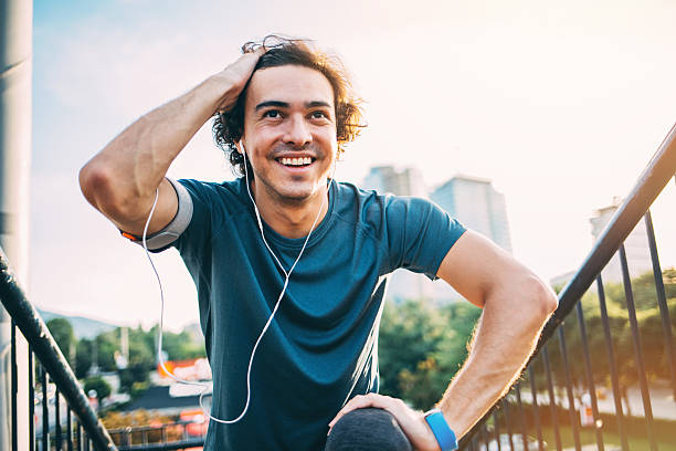 Sportsman in the city Young man in sports wear and with portable information devices making exercises at sunlight outdoors in the city pedometer photos stock pictures, royalty-free photos & images