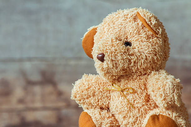 istock Cute teddy bears sitting on old wood background 564579230