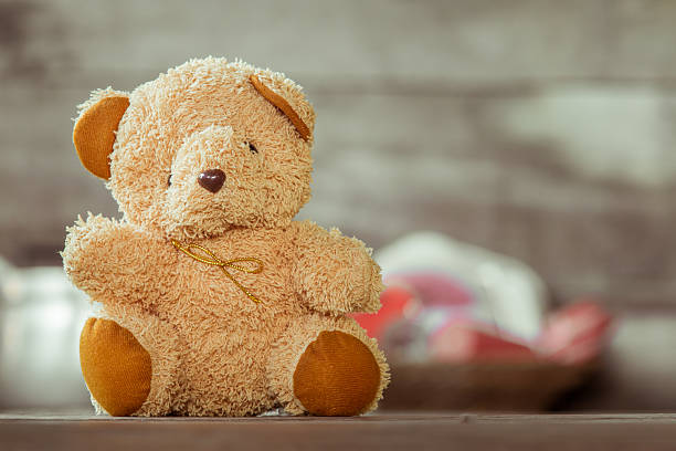 istock Cute teddy bears sitting on old wood background with copyspace 564581968