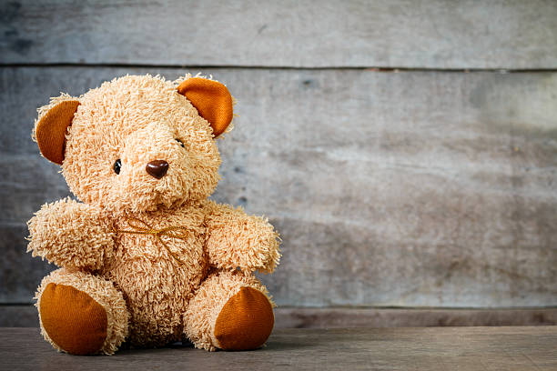 istock Cute teddy bears sitting on old wood background 564584598