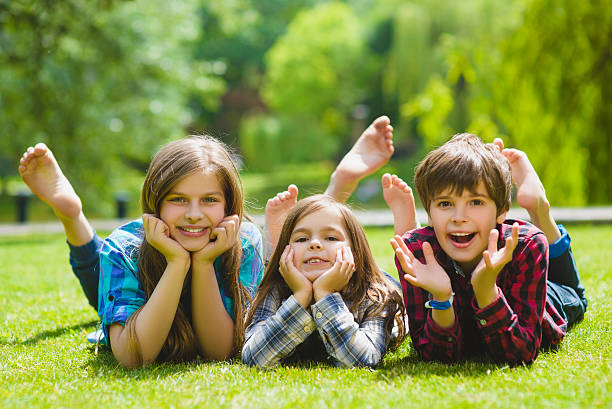 istock Smiling kids having fun at grass. Children playing outdoors in 564585406