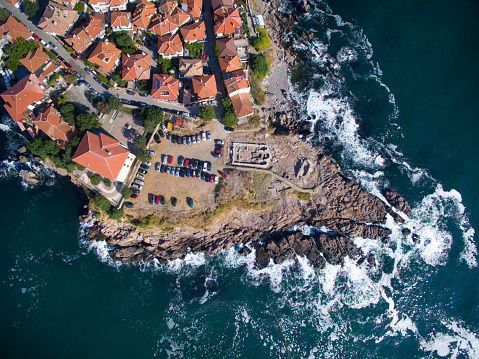High angle view of Sozopol, Bulgaria. Houses and vehicles, old ruins on rocks.