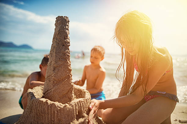 istock Kids building a sandcastle on a beautiful beach 564587762
