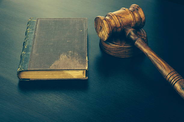 istock Judges Hammer or Gavel With Old Book On Dark Background 564587986