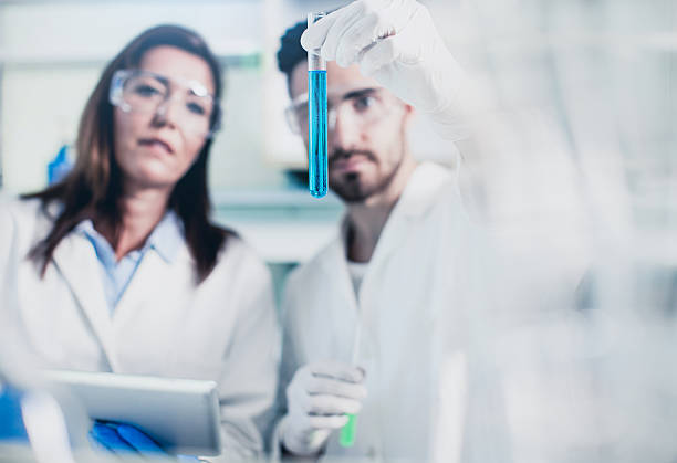 istock Scientists Looking at a Test Tube Filled With Dilution 564588838