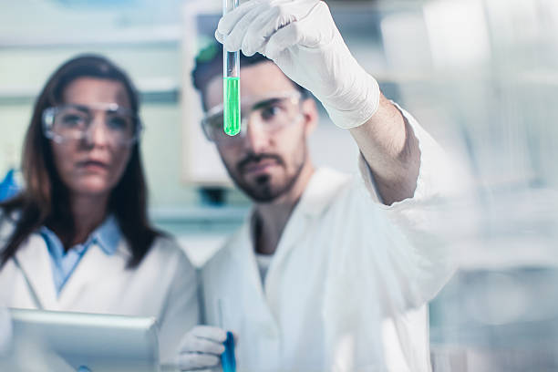 istock Scientists Looking at a test Tube Filled With Dilution 564588860