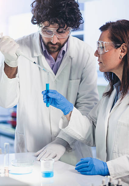 istock Scientists Pipetting Into a Test Tube 564588964