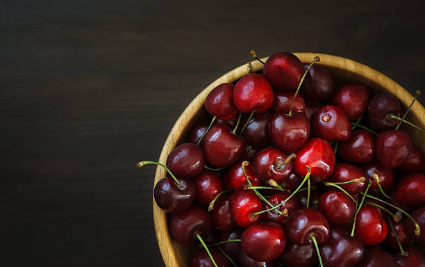 istock fresh cherries on wooden table 564591666