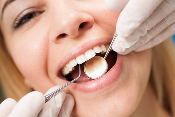 Young confident woman at  dentist's office having routine checkup. stock photo