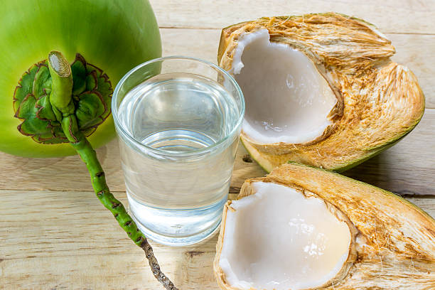 kokoswasser und frische kokosnuss auf holzhintergrund - green ground juice freshness stock-fotos und bilder