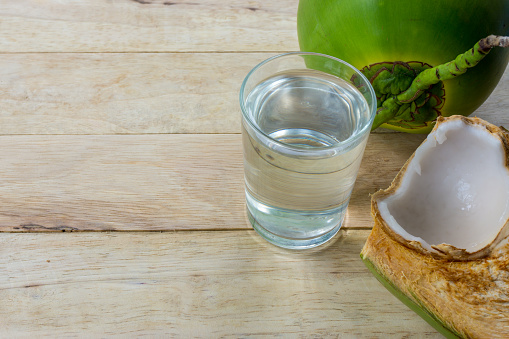 coconut water and fresh coconut on wooden background
