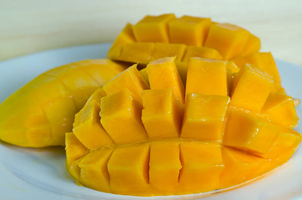 istock Mango nicely cut on the plate on wooden background 564598794