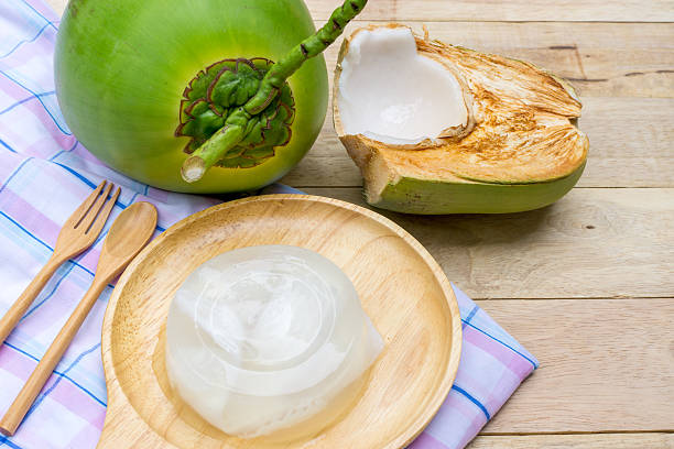 gelatina di cocco e cucchiaio di legno su sfondo di legno - agar jelly foto e immagini stock