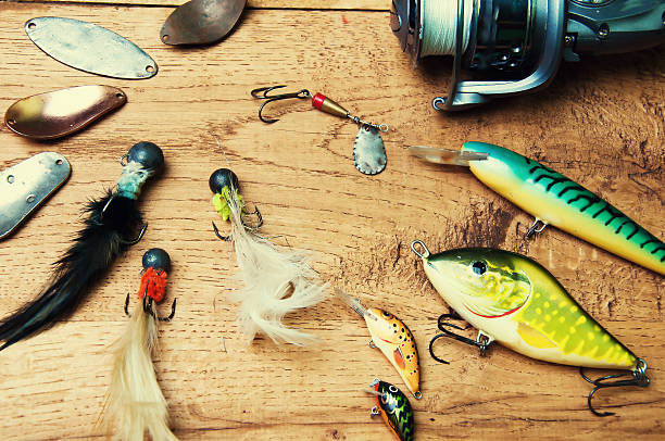 istock Fishing baits and rod isolated on wooden background 564598888