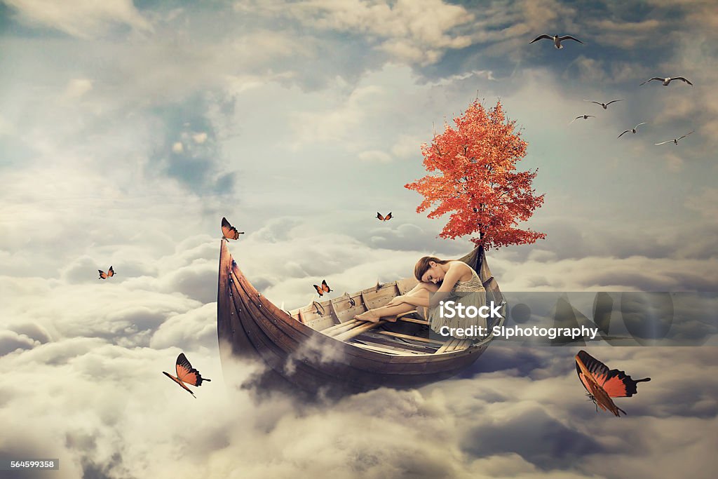 Joven mujer solitaria a la deriva en bote por encima de las nubes. Salvapantallas de ensueño - Foto de stock de Onírico libre de derechos