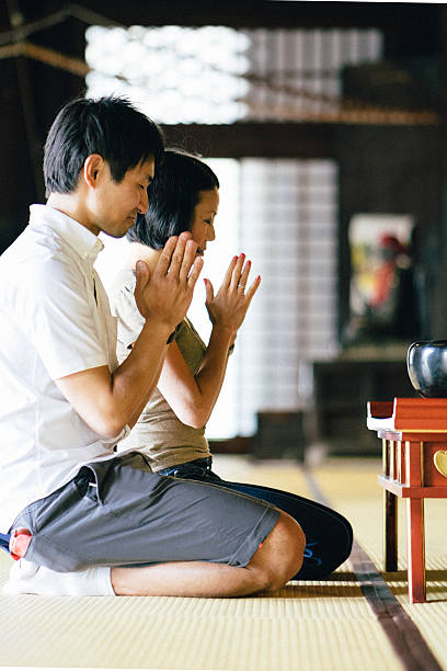 istock Japanese couple praying in a buddhist temple 564599810