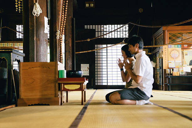istock Japanese couple praying in a buddhist temple 564600520