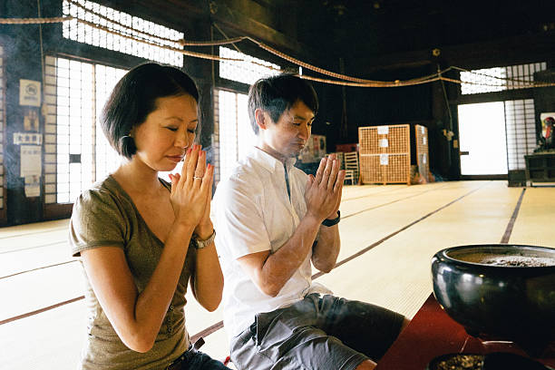 istock Japanese couple praying in a buddhist temple 564600984