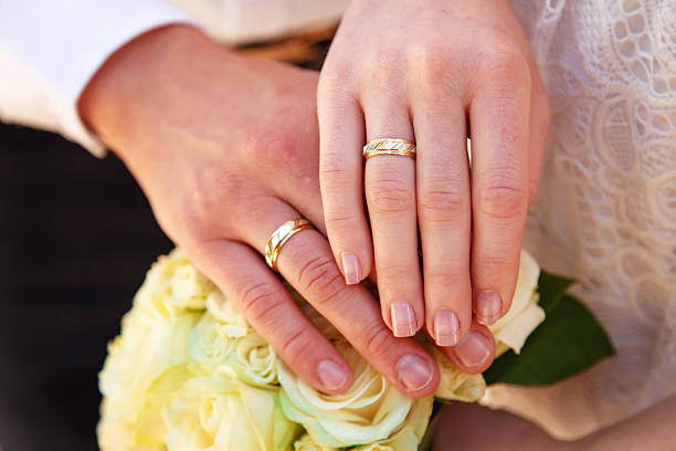 istock Hands and rings on wedding bouquet 564601006