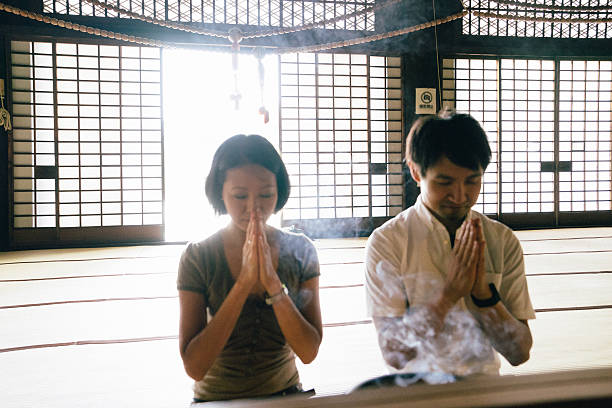 istock Japanese couple praying in a buddhist temple 564601318